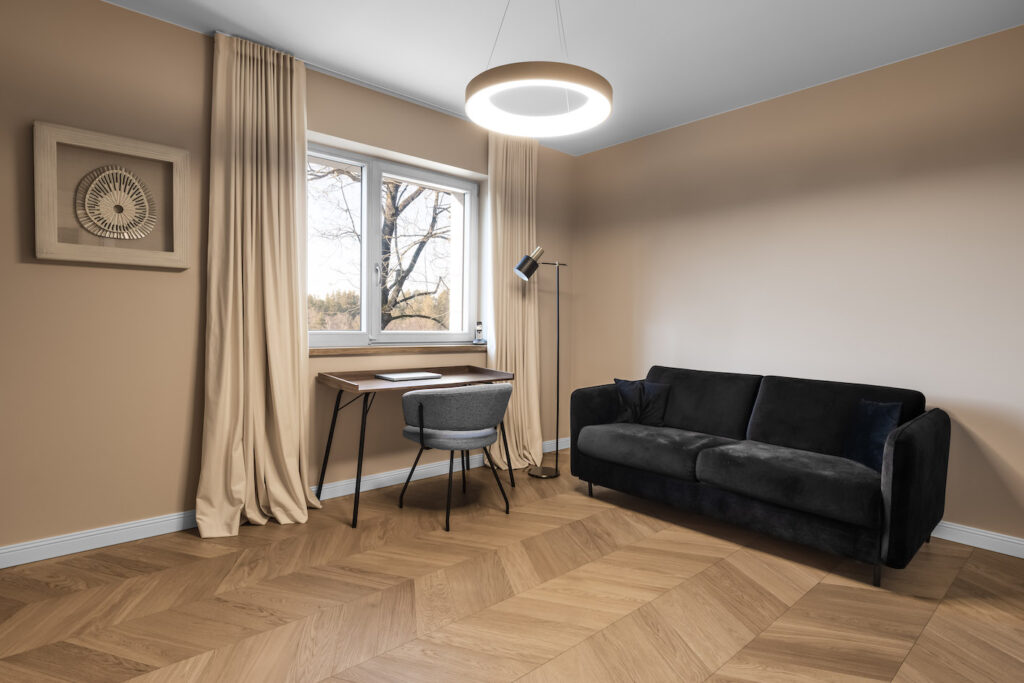 darbo kambario interjeras su juoda sofa