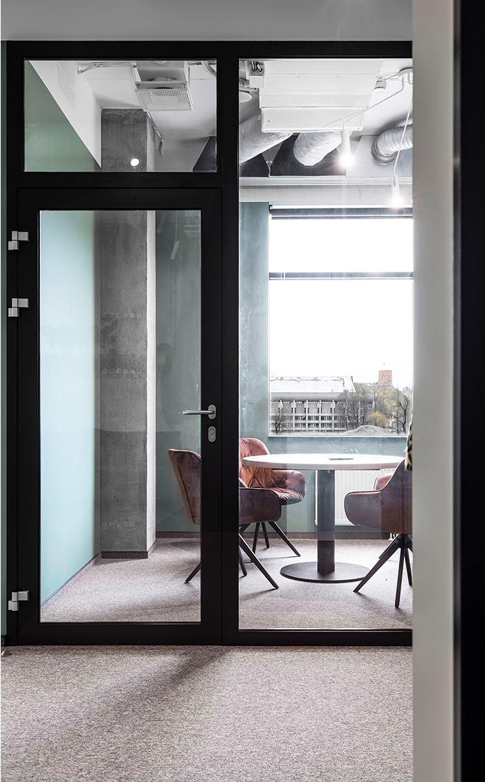 rudas kilimas pasitarimų kambaryje ir oranžinės aksominės kėdės bei vaizdas į Gedimino pilį