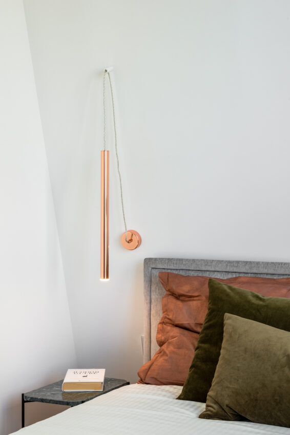 pilka dvigulė miegamojo lova su žaliomis ir oranžinėmis pagalvėmis