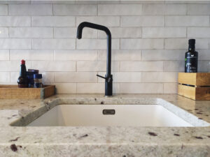 granito stalviršis su iš apačios klijuojama kriaukle