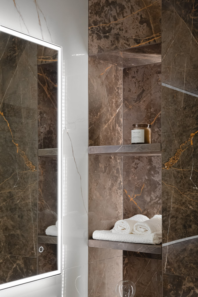 Balti vonios rankšluosčiai tamsiame vonios kambaryje