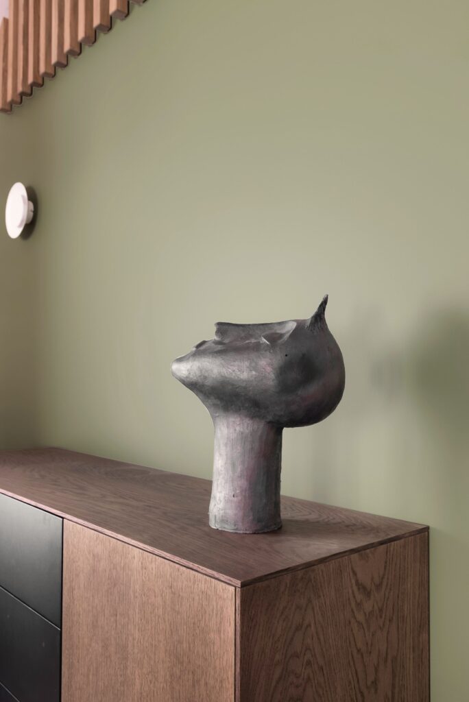 Skulptūra ant medinės spintelės